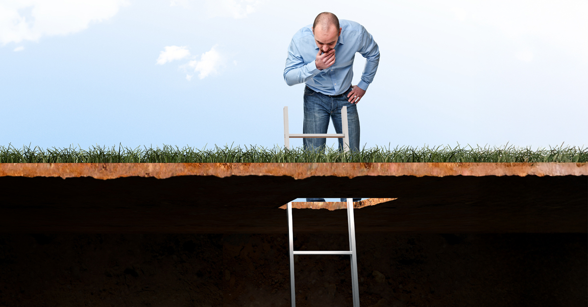 Man looking in hole